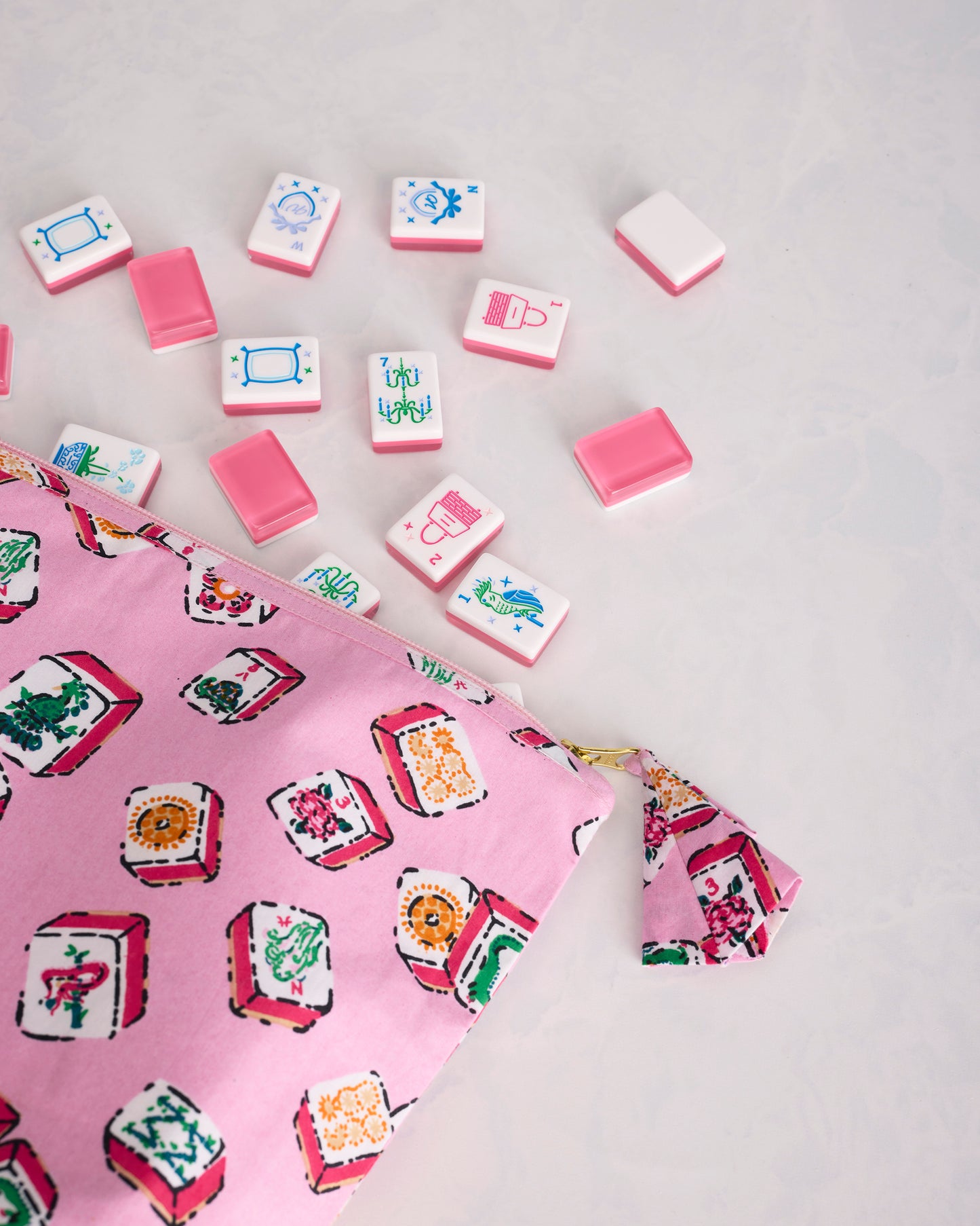 Close view of the Lucky Tiles pouch print, zipper, and matching pull tab beside Mah Jongg tiles