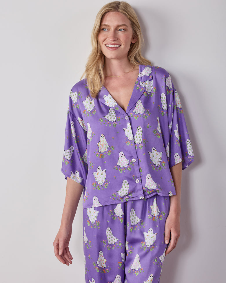 Front view of the purple Gardening Ghosts pajama set with a collared button-front top and wide-leg pants covered in a white ghost-and-floral print.