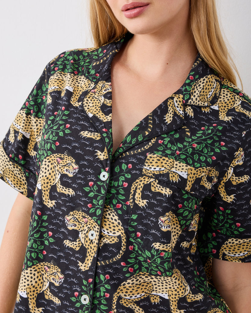 Close-up of the short-sleeve pajama top with leopards and flowering vines on a dark background