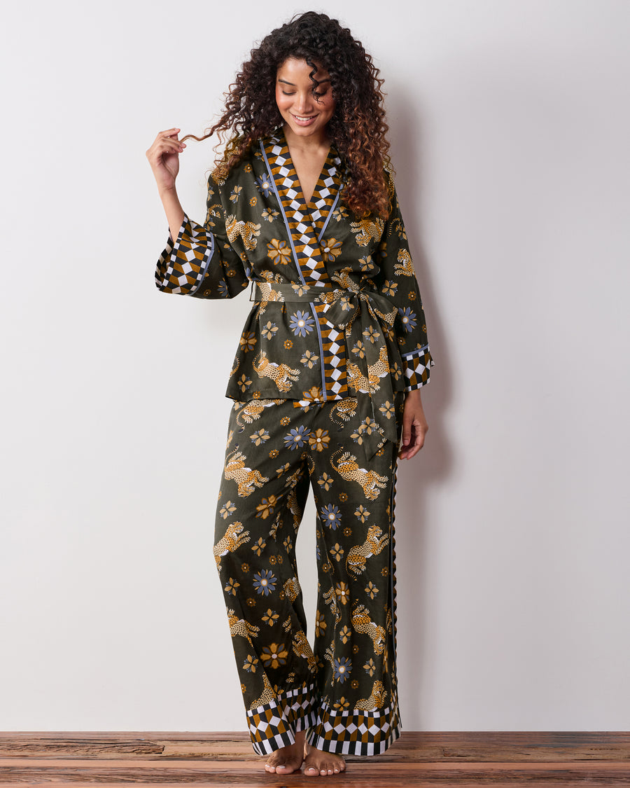 Front view of a person wearing the petite olive Bagheera Kaleidoscope wrap set, showing the tied waist, wide-leg pants, leopard-and-flower print, and geometric trim.