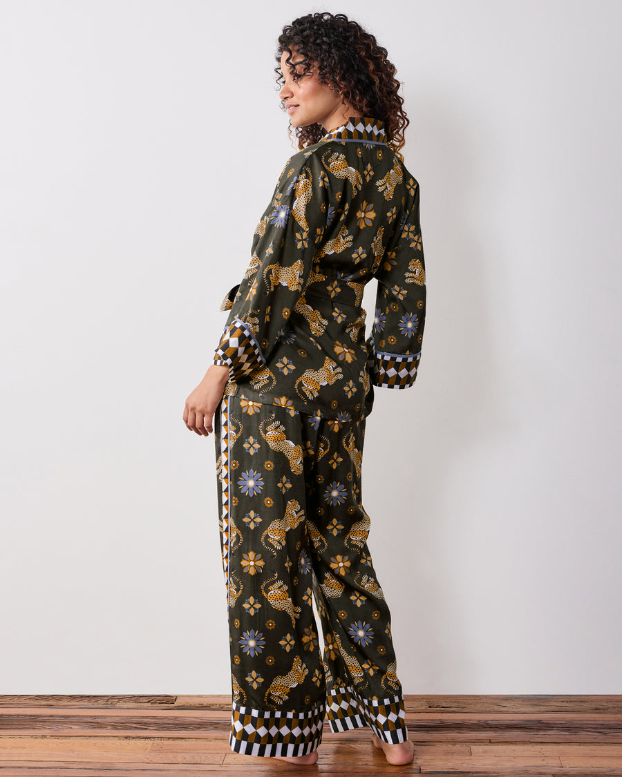 Back three-quarter view of a person wearing the olive Bagheera Kaleidoscope wrap set, showing the back print, waist tie, and geometric cuffs.