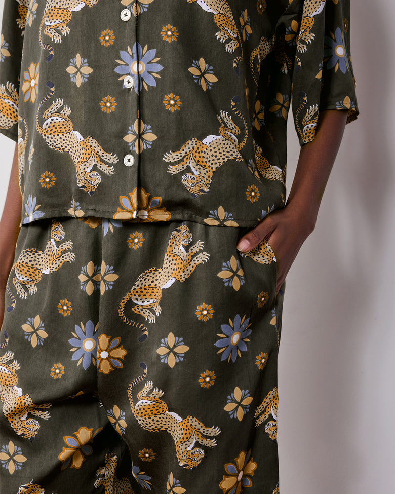 Close view of the olive Wildest Dreams pajama shirt and matching pants, showing the leopard and flower print and side pocket.