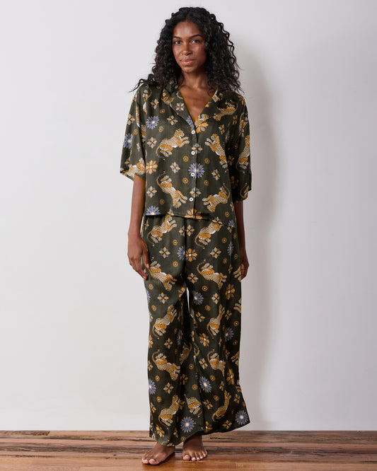 Full-length front view of the olive Wildest Dreams pajama set with a short-sleeve button-front shirt and wide-leg pants featuring leopard and flower prints.