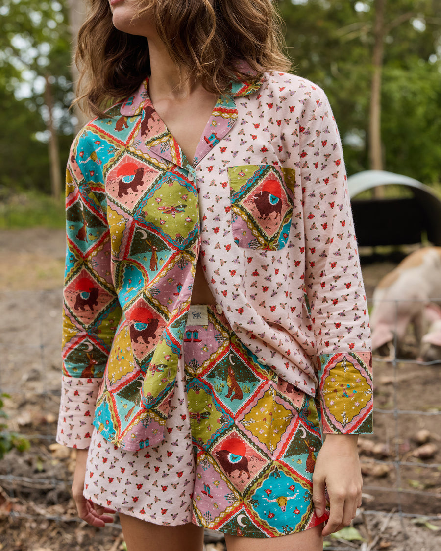 Close front view of a patterned pajama shirt with a collar, buttons, and chest pocket, paired with matching shorts.