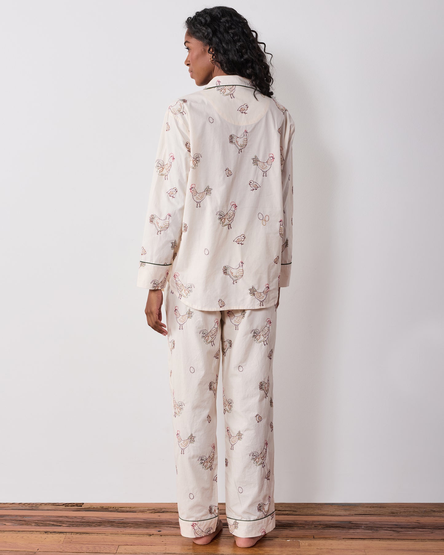 Back view of the long pajama set with embroidered hens across the button-front top and full-length pants.