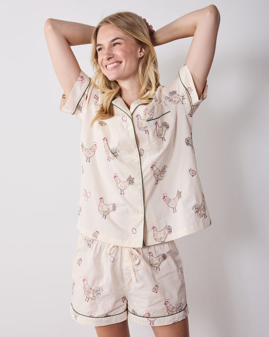 Front view of the short pajama set with a short-sleeve button-front top and matching shorts featuring embroidered hens.