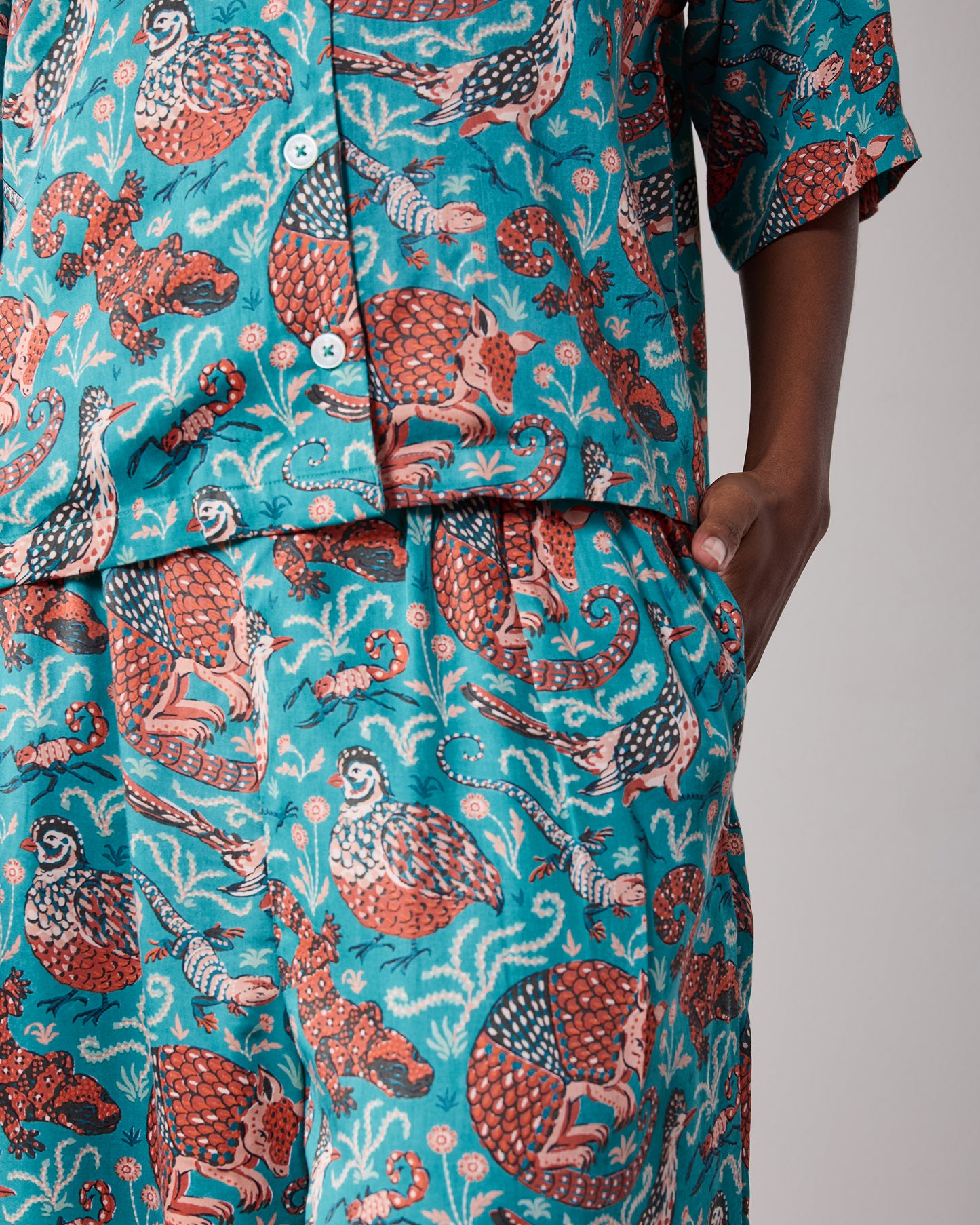 Close view of the pajama top and pants showing the patterned fabric and side pocket.