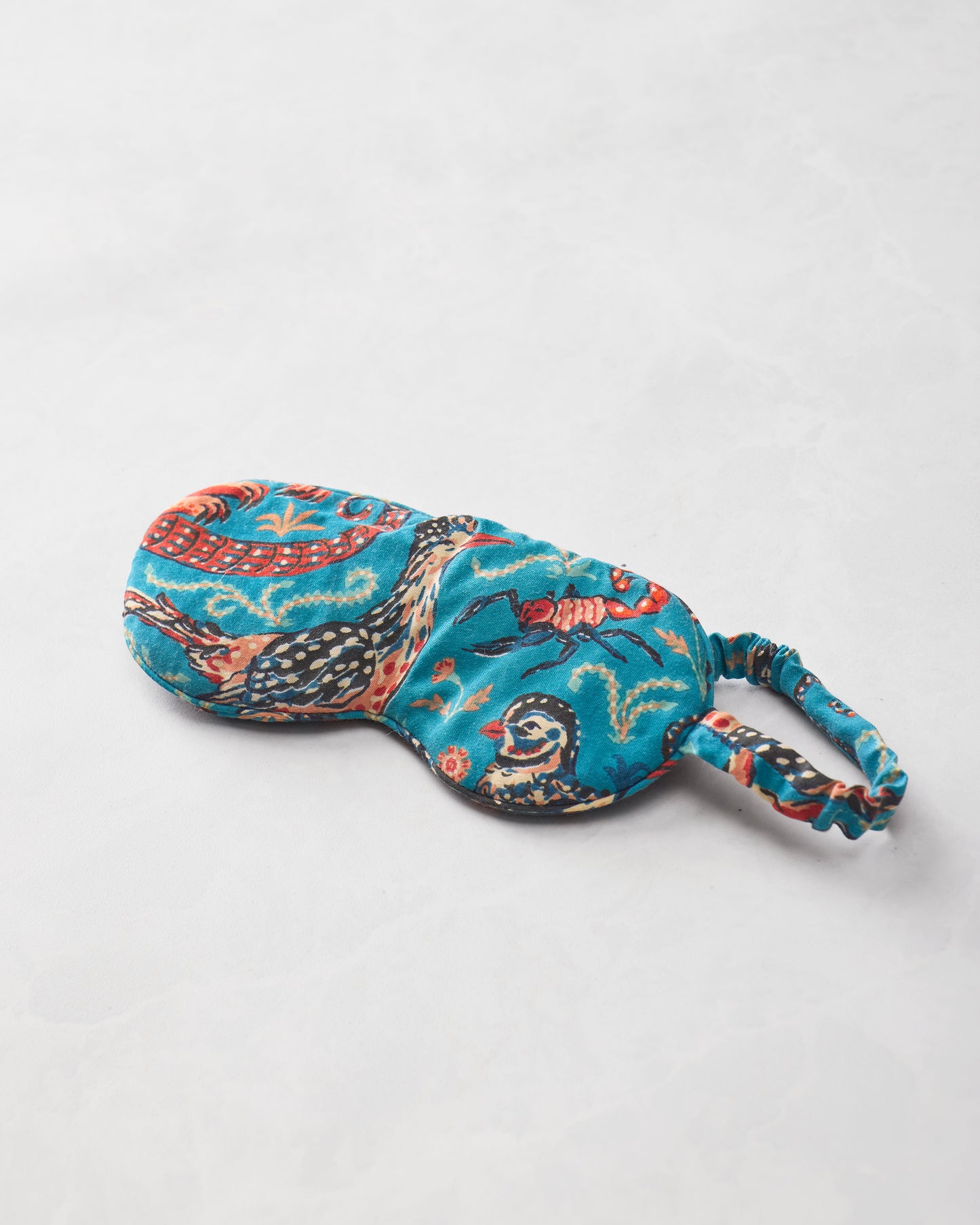 Teal Southwestern Critters eyemask isolated on a light background, showing illustrated animals and an elastic strap.