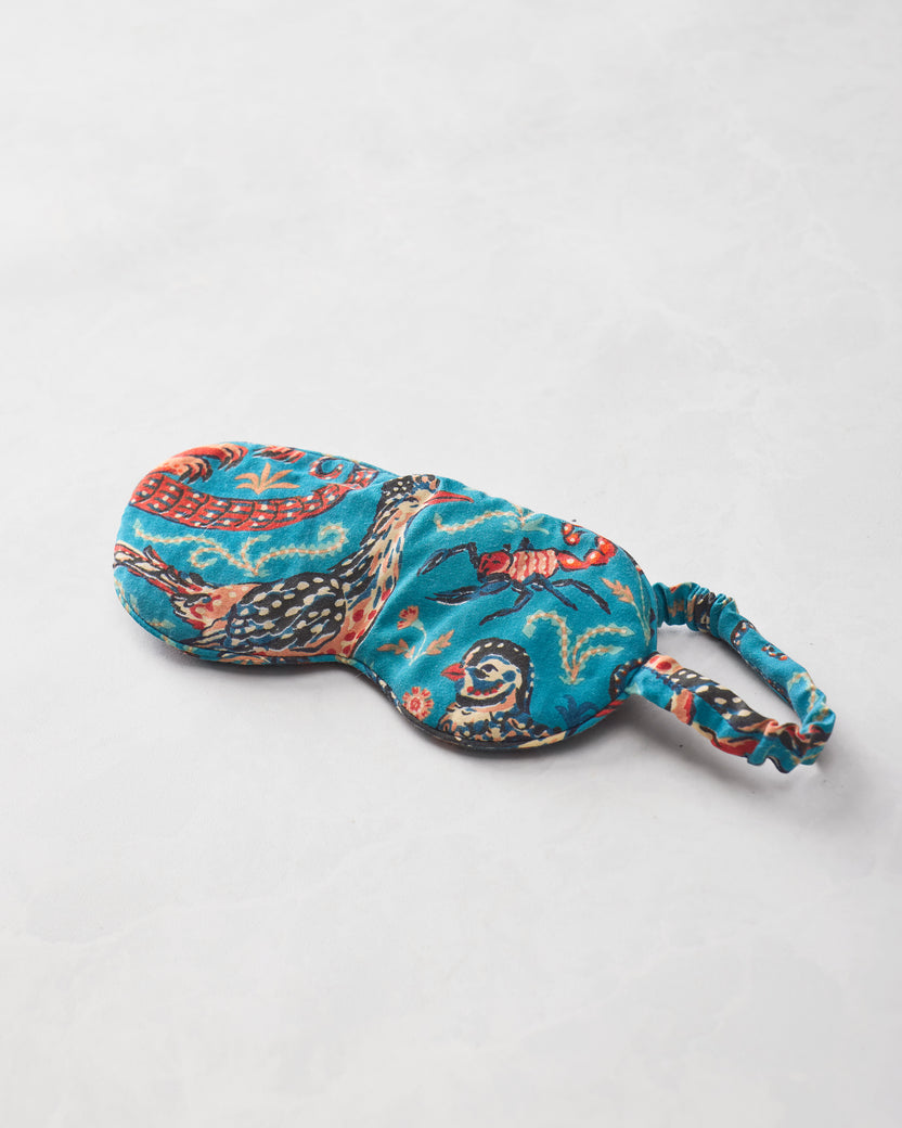 Teal Southwestern Critters eyemask isolated on a light background, showing illustrated animals and an elastic strap.