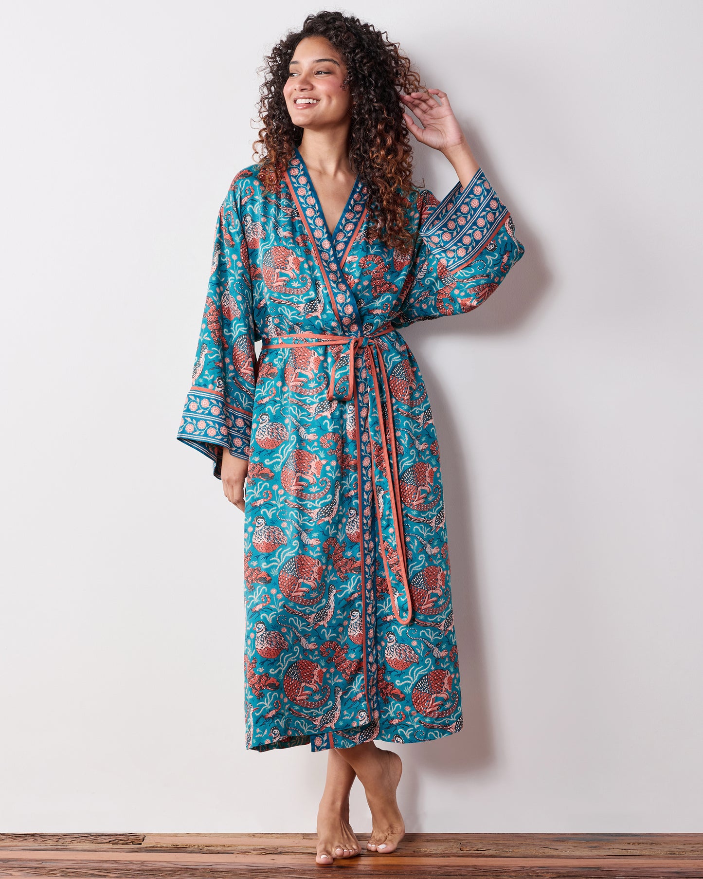 Full-length view of the teal Southwestern Critters satin robe with a wrap front, tie belt, wide sleeves, and patterned trim.