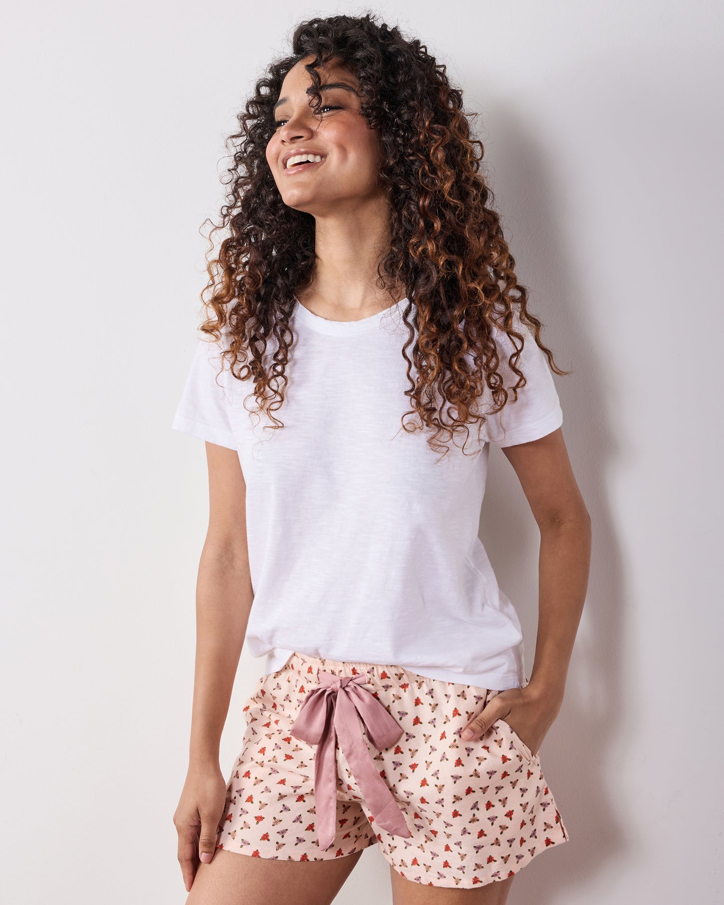 Close front view of a model wearing the Western Scenes Astrid shorts, showing the tied waist bow, side pocket, and repeating print.