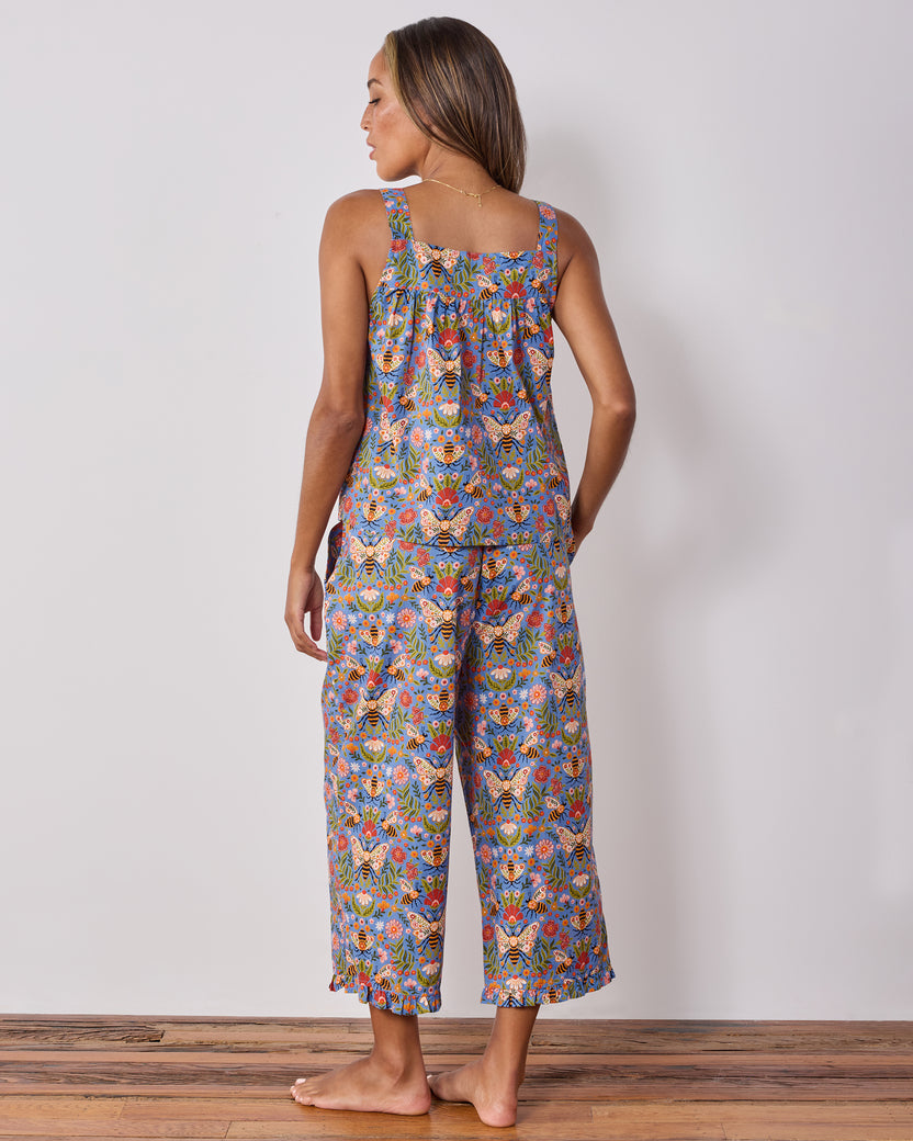 Back view of a sleeveless pajama top and wide-leg cropped pants with a blue bee-and-floral print.