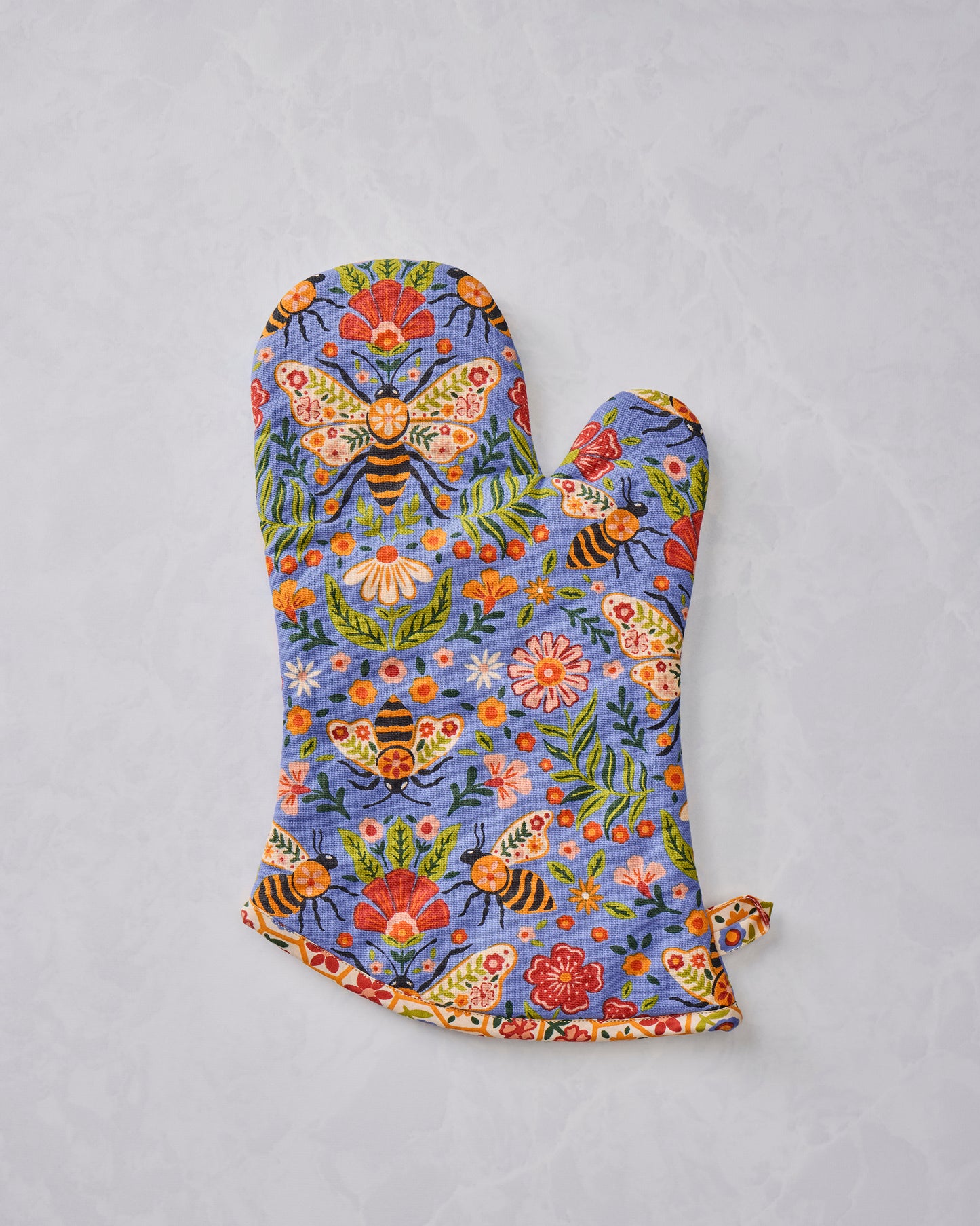 Single blue floral oven mitt printed with bees, butterflies, flowers, and leaves.