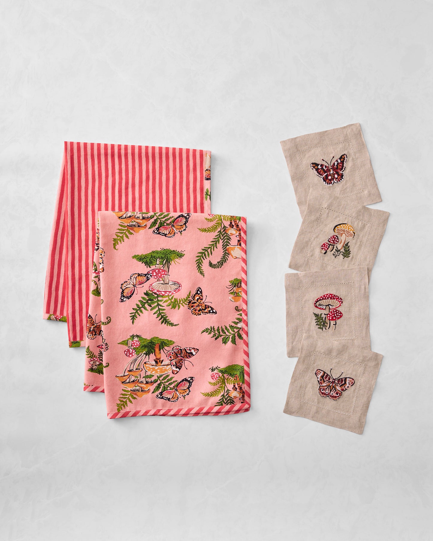 Butterfly Forager bundle with pink printed tea towels, a striped towel, and four embroidered cocktail napkins.