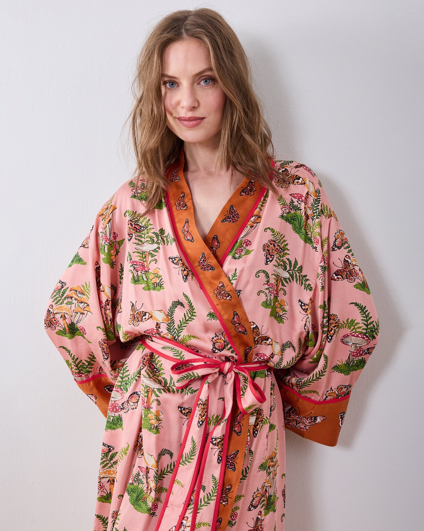 Front view of the rosewood Butterfly Forager robe with a wrap front, matching waist tie, and contrasting brown trim.