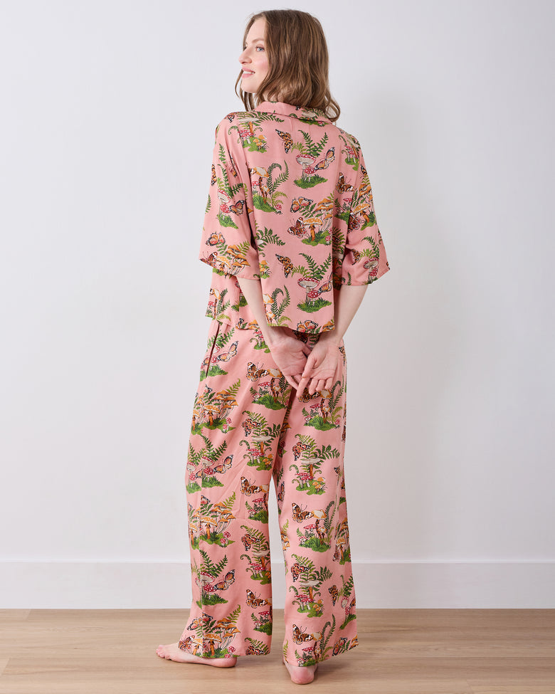 Back view of the pink Butterfly Forager tall satin Wildest Dreams pajama set with a short-sleeved top and wide-leg pants.