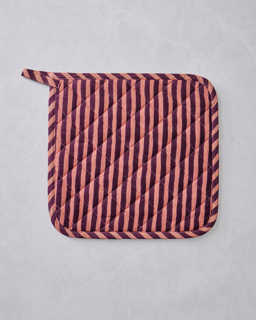 Quilted Champagne & Caviar pot holder with diagonal burgundy and peach stripes and rounded corners, shown flat.