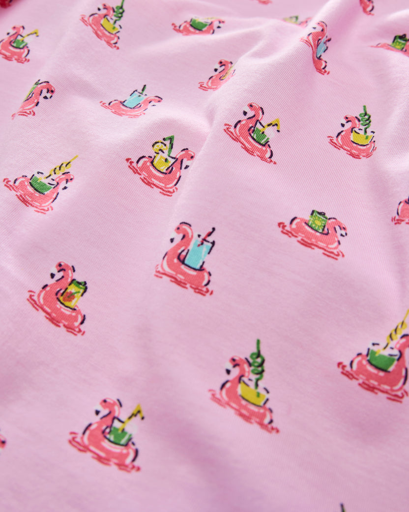 Close-up of pink fabric with flamingos floating in inner tubes and colorful drinks