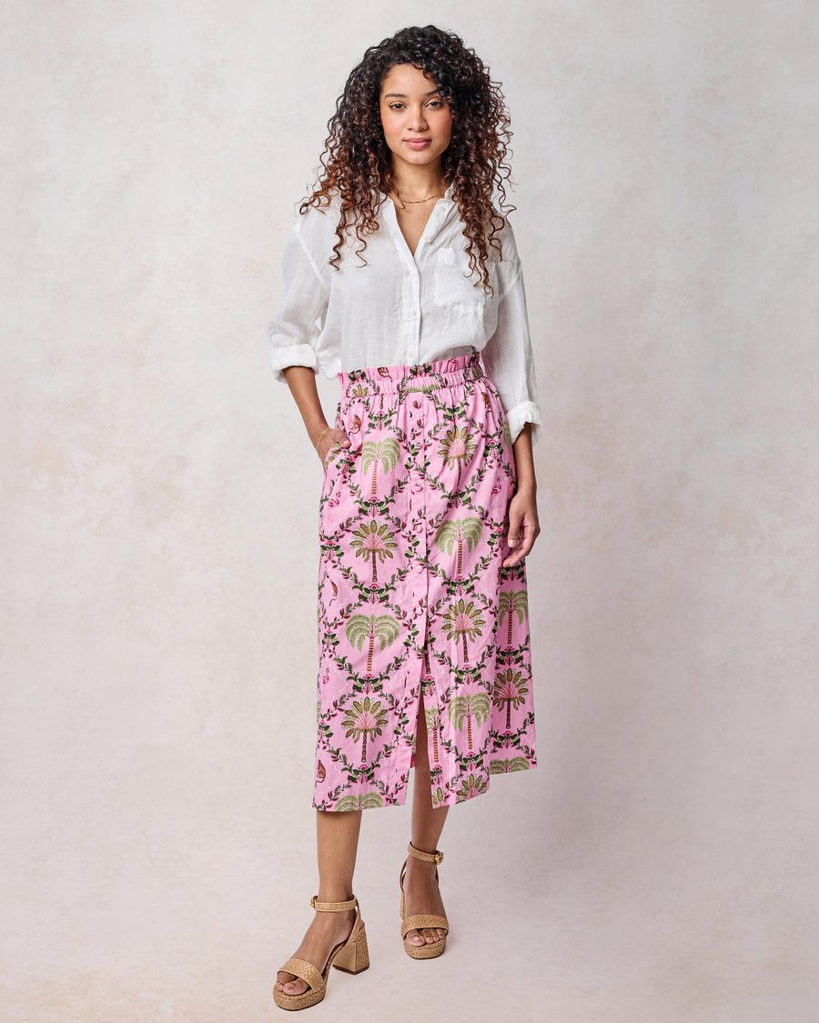 Front view of pink tropical-print midi skirt with a gathered waist, pockets, and button front