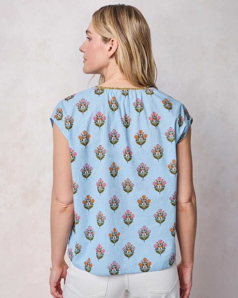 Back view of soft blue Jordan blouse with cap sleeves and a repeating floral motif