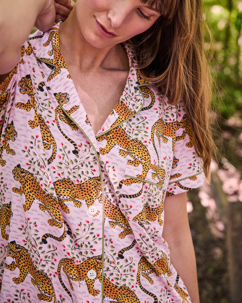 Close view of the blush Bagheera short pajama top showing its collar, button front, pocket, piping, and leopard print.