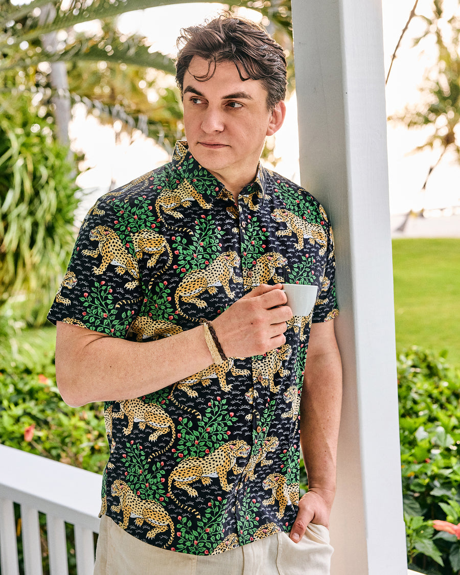 Model wearing the Ink Bagheera Leo Shirt and holding a small cup on a porch