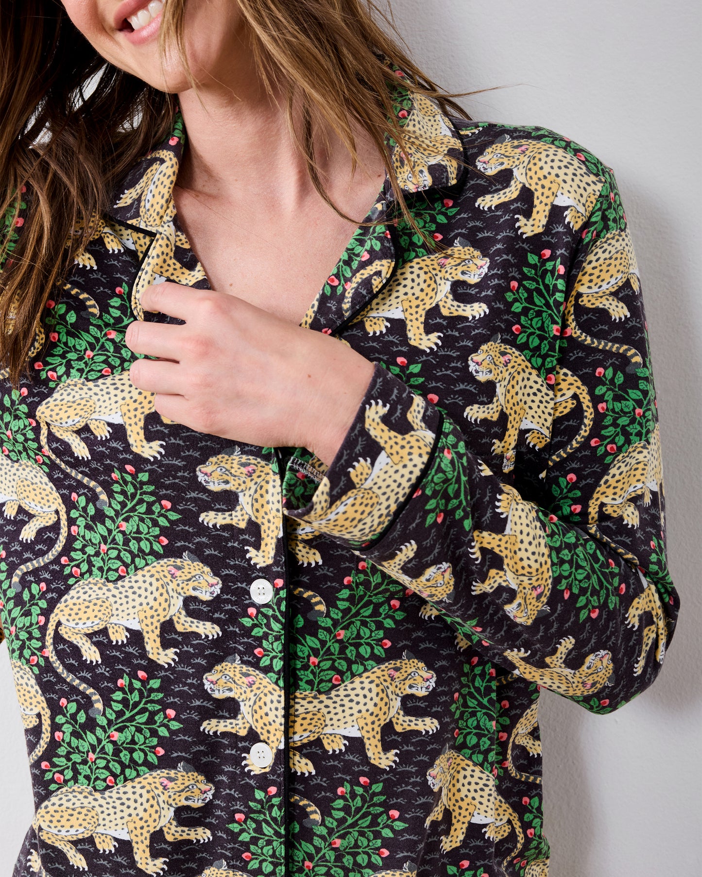 Close-up of the Bagheera long pajama shirt showing its collar, white buttons, long sleeve, and leopard-and-greenery print.