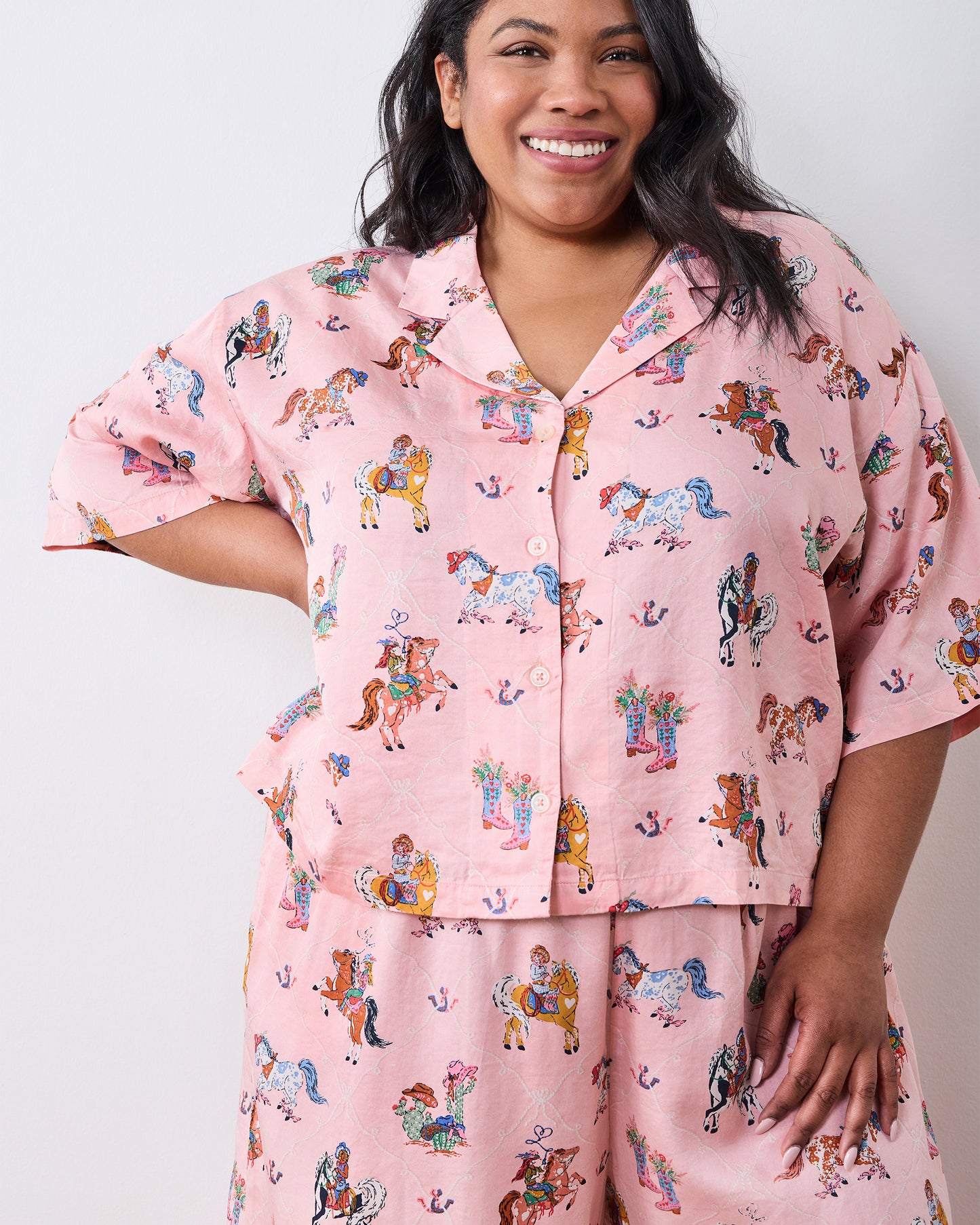 Close-up of the pink cowgirl-print petite pajama top with a notched collar, short sleeves, and front buttons.