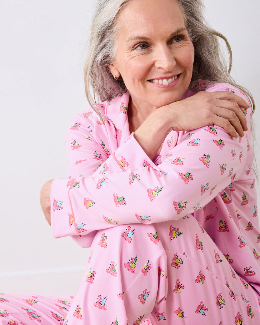 Seated model in the pink Flamingo Floaties long pajama set, with the printed sleeves and pants in close view