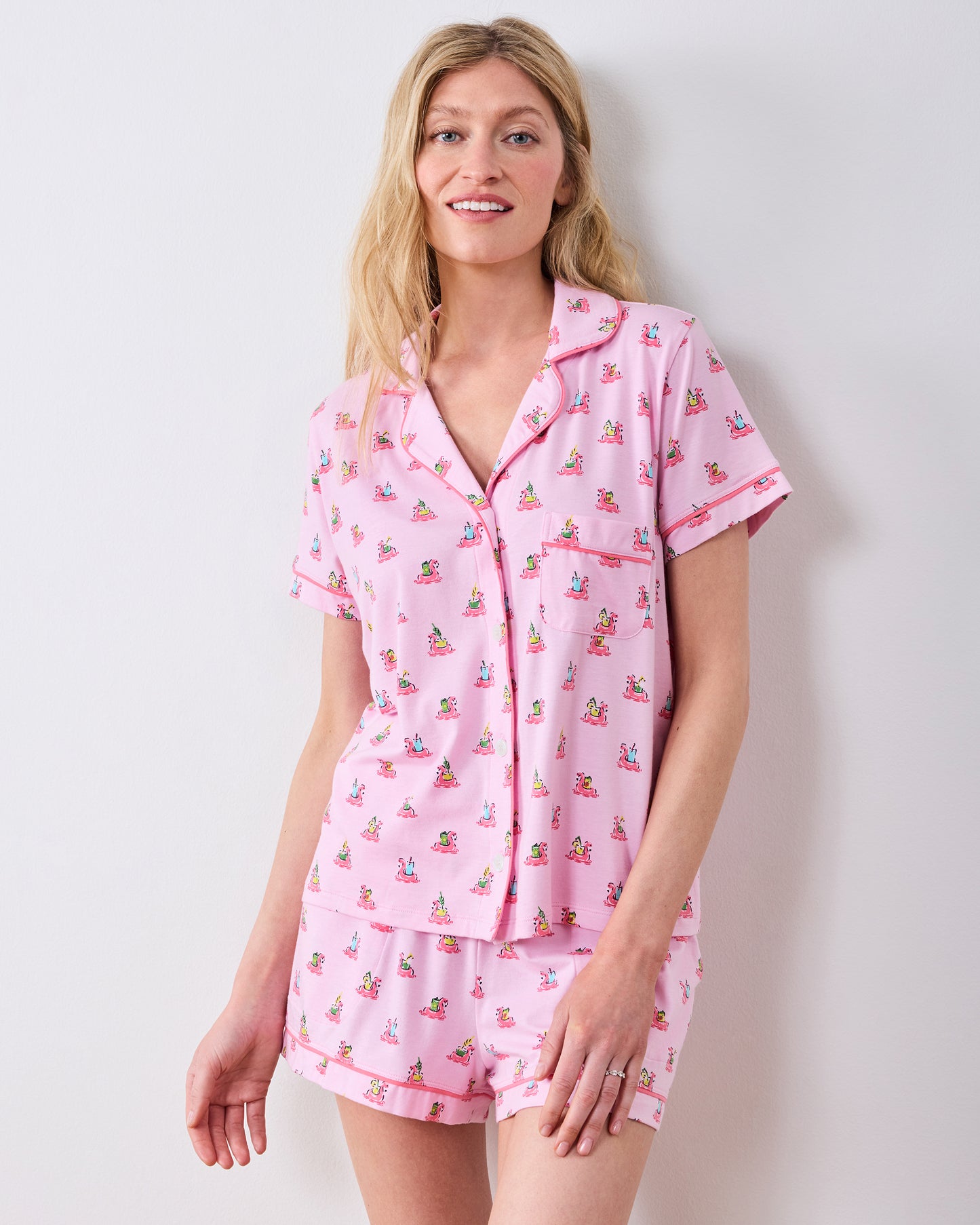 Front studio view of the pink flamingo-print button-down pajama top and matching shorts