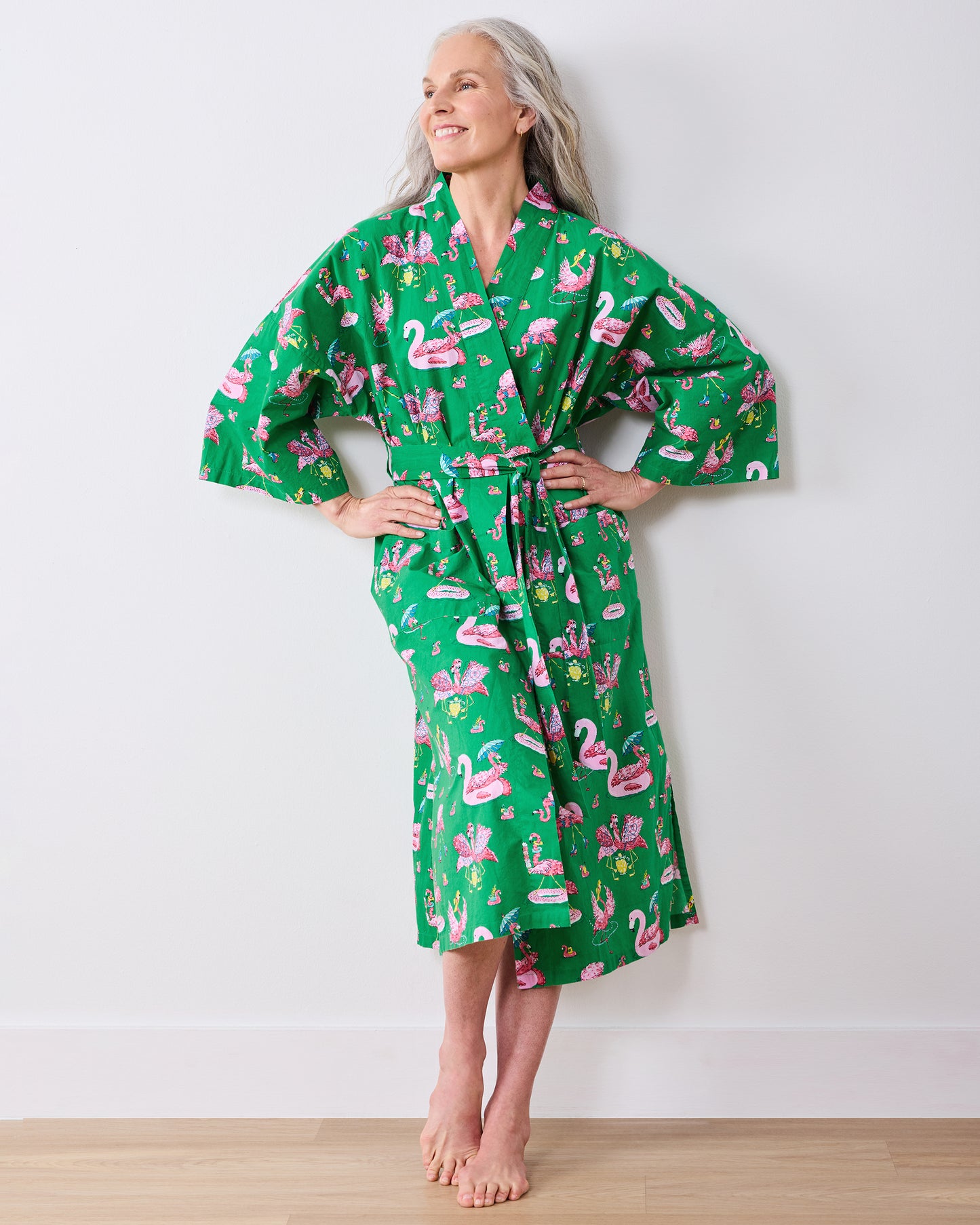 Full-length front view of the green flamingo-print long robe tied at the waist