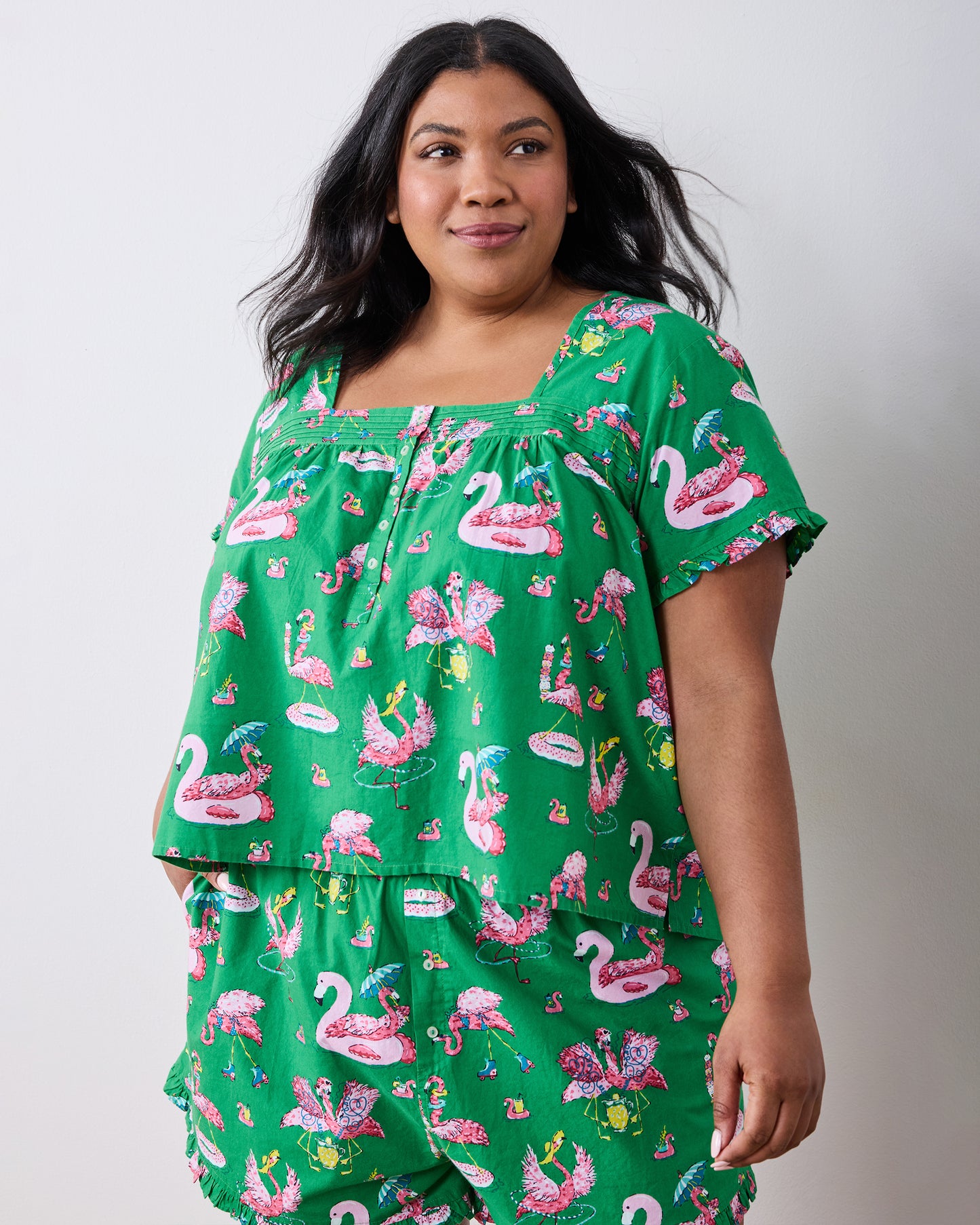 Front three-quarter view of the green flamingo-print pintuck top and matching shorts