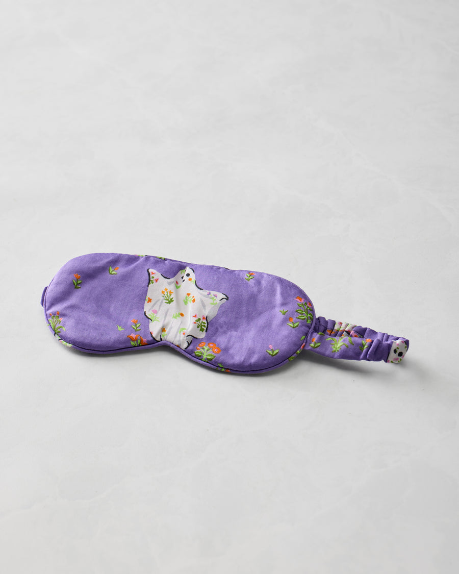 Purple eye mask with a white ghost appliqué, small floral motifs, and an adjustable gathered strap.