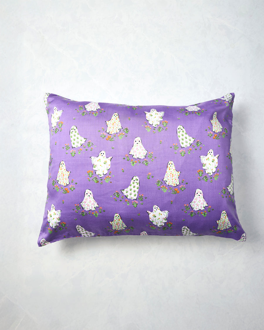 Eerie Amethyst pillowcase displayed flat with a purple background and a repeating print of white ghosts surrounded by small flowers.