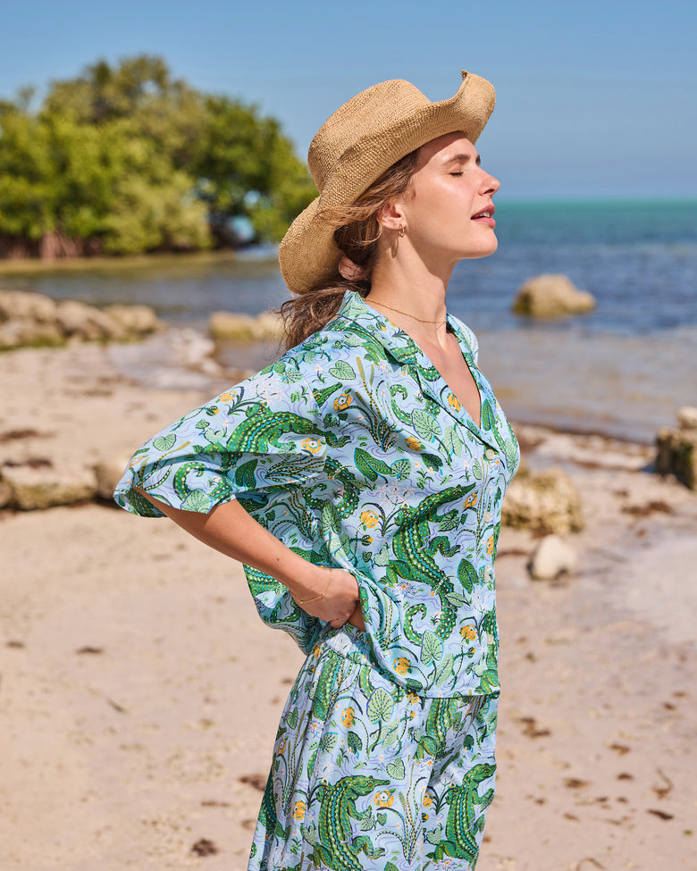 Side view of the gator-print pajama top and matching pants worn on a beach