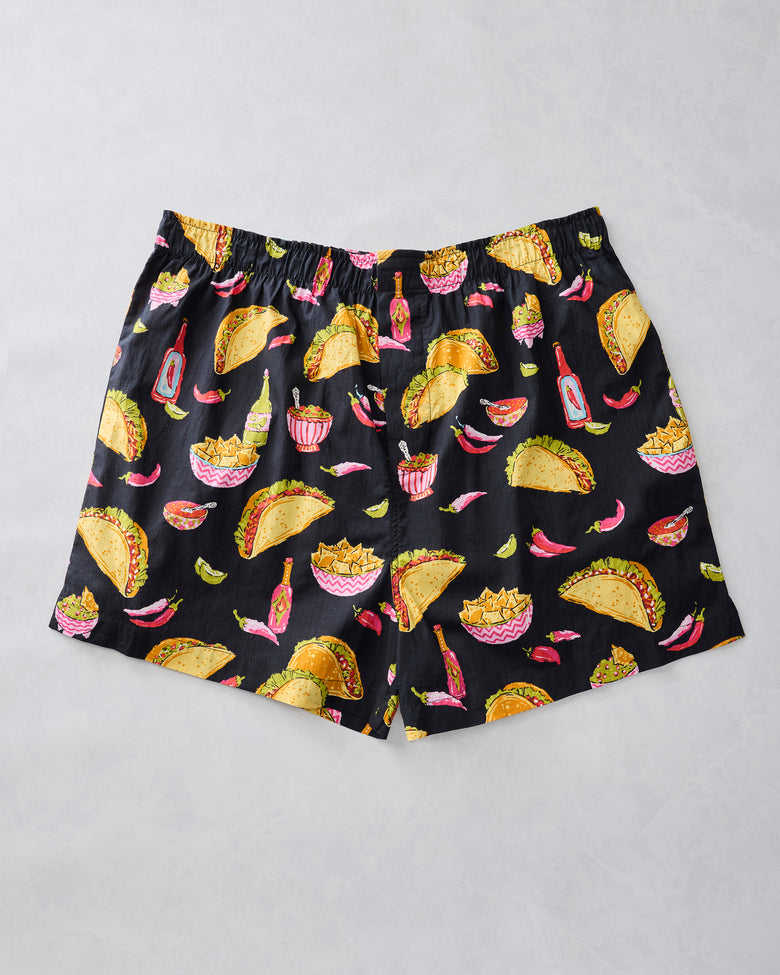 Lava Rock boxer shorts laid flat with tacos, nachos, peppers, salsa, and bottles on a black background
