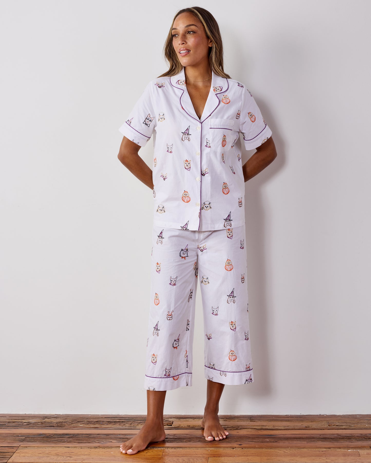 Full-length front view of a person wearing the Halloween Hounds short-sleeve top and cropped pants pajama set.