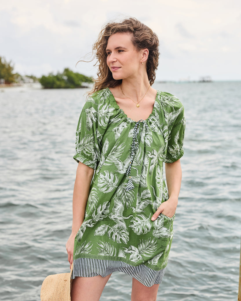 Three-quarter front view of the olive grove Annie Dress showing the gathered neckline, side pocket, and striped hem