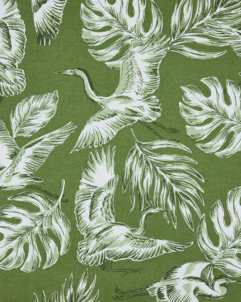 Close-up of the Heron Landing print with white herons and tropical leaves on an olive-green background