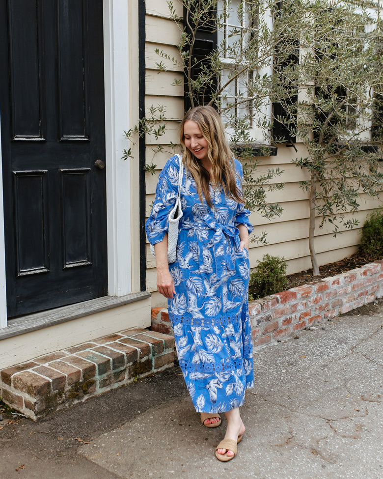 Person wearing the blue Heron Landing Monroe midi dress with a belt and pockets outdoors.