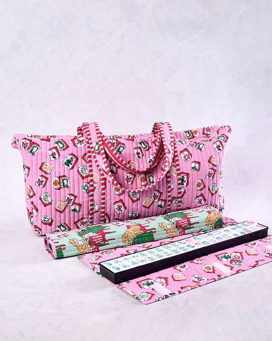 Peony pink quilted Mah Jongg bag with handles and a printed tile pattern, shown with a rolled item, game rack, and mat.