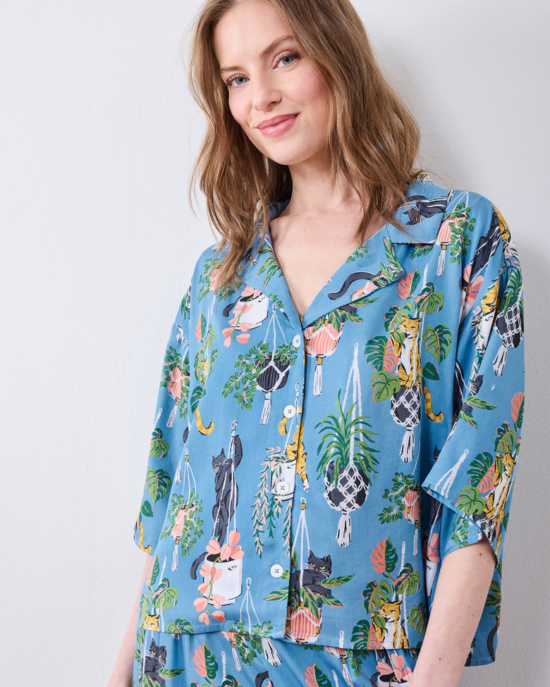Close front view of the slate blue pajama top with cats and hanging plants print