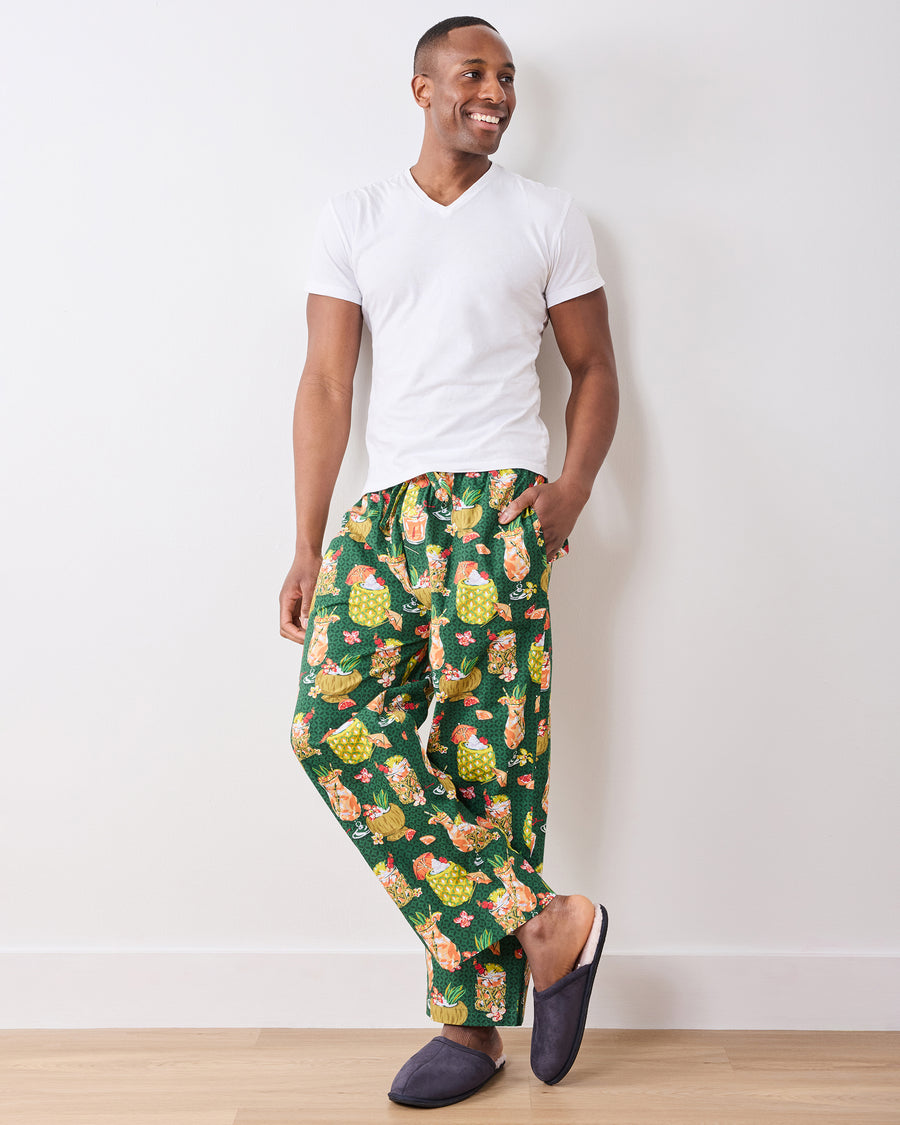 Full-length front view of a model wearing green Paradise Punch pajama pants with slippers