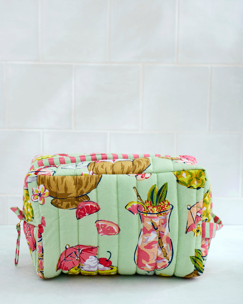 Front view of the mint-green Mojito quilted pouch with tropical drink print and zip closure