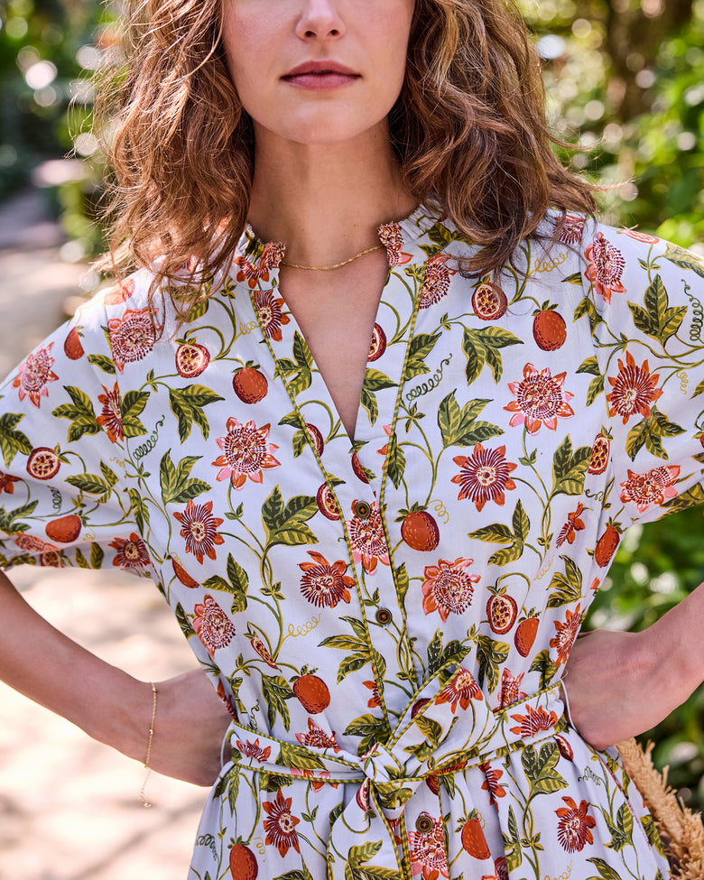 Close-up of the Presley Dress showing its button front, open collar, self-tie belt, and Passion Vine print