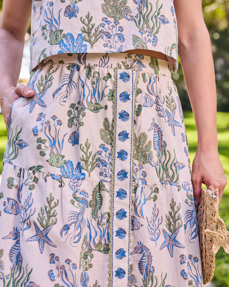 Close-up of the Tessa skirt's waistband, pocket, shell-trimmed button placket, and sea life print