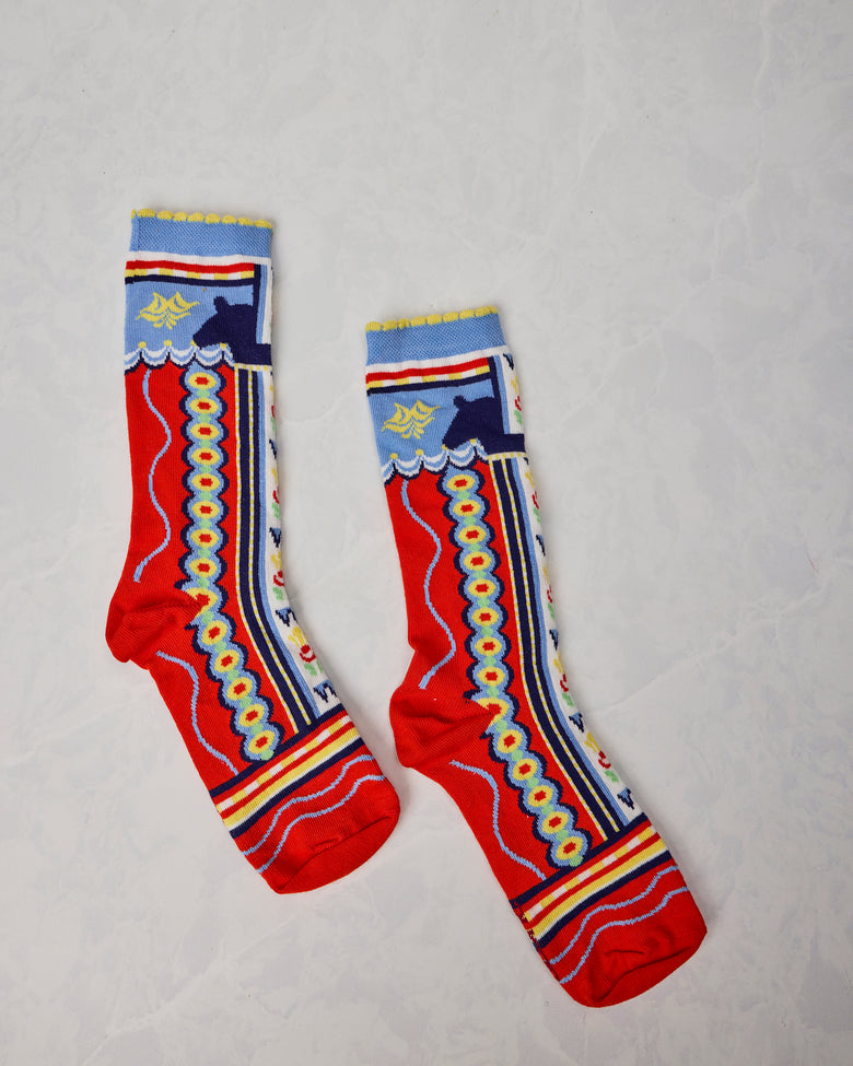 Pair of colorful Dala Horse socks displayed separately, with red, blue, yellow, and white patterned designs.