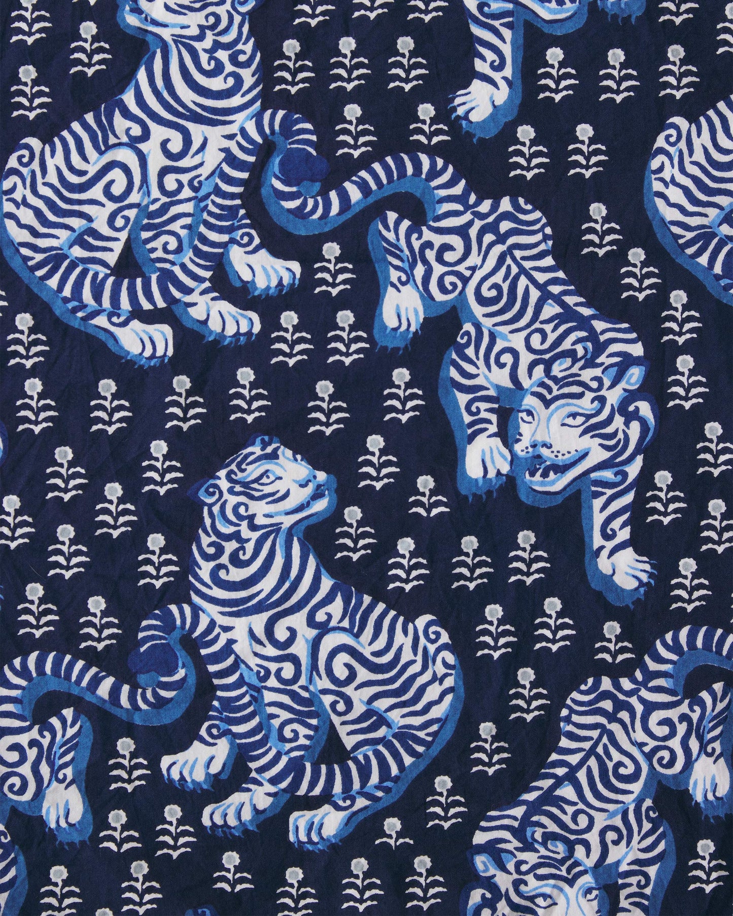 Close-up of the indigo print with stylized white and blue tigers and small floral motifs.