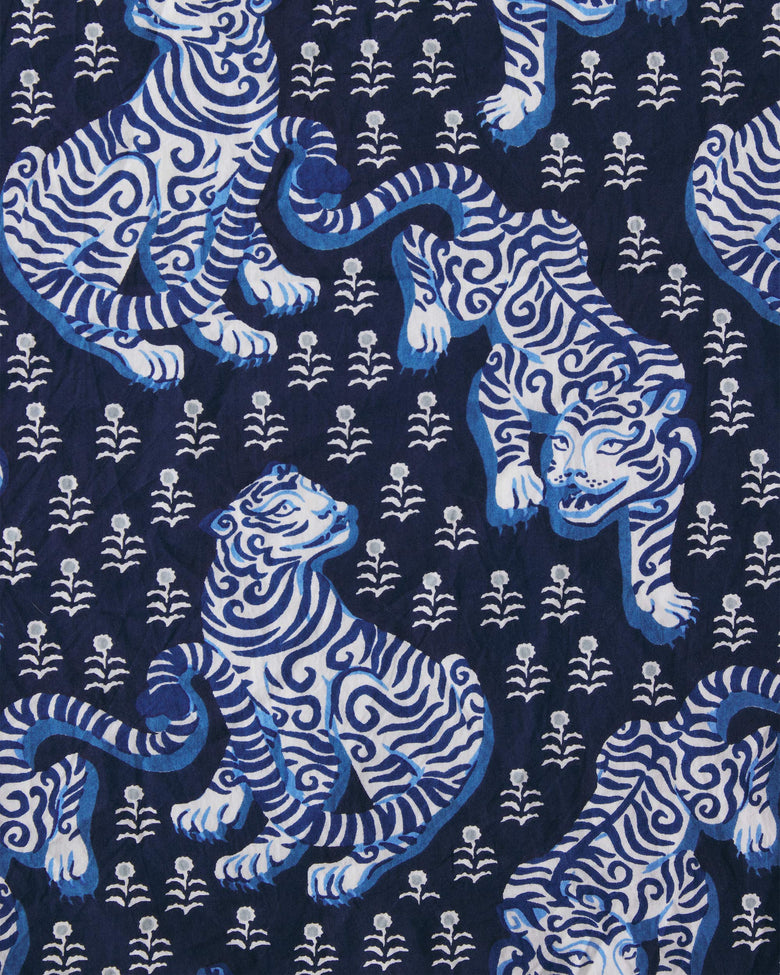 Close-up of the indigo print with stylized white and blue tigers and small floral motifs.