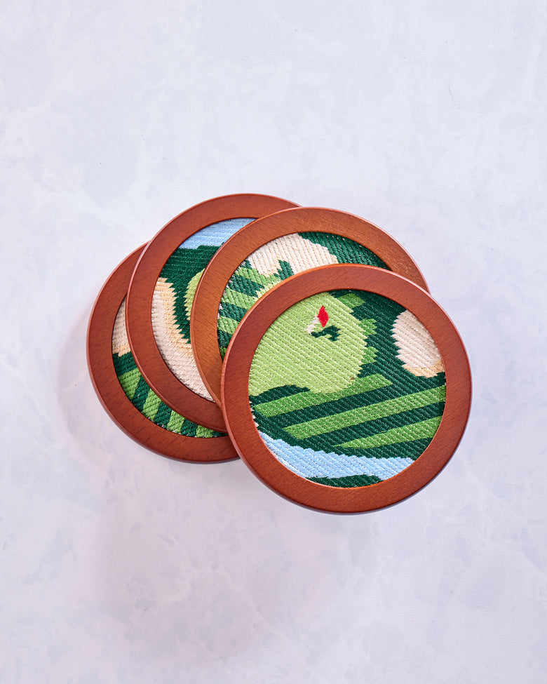 Four overlapping round green stitched golf coasters showing varied sections of the golf-themed designs.